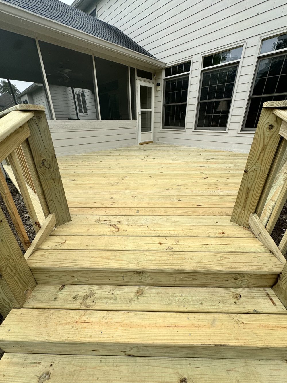 New wood deck steps leading down from a covered porch