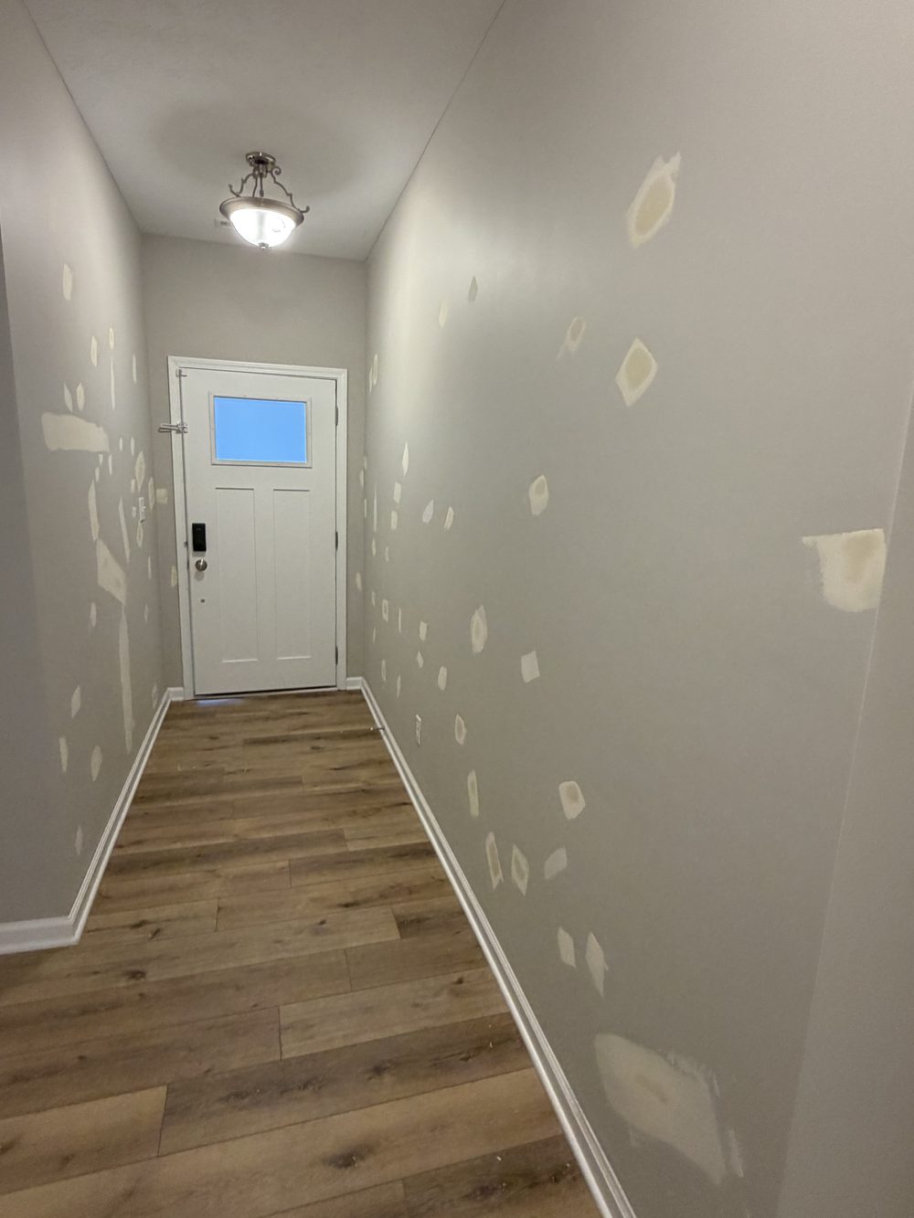 Hallway walls with drywall patches sanded and ready for paint