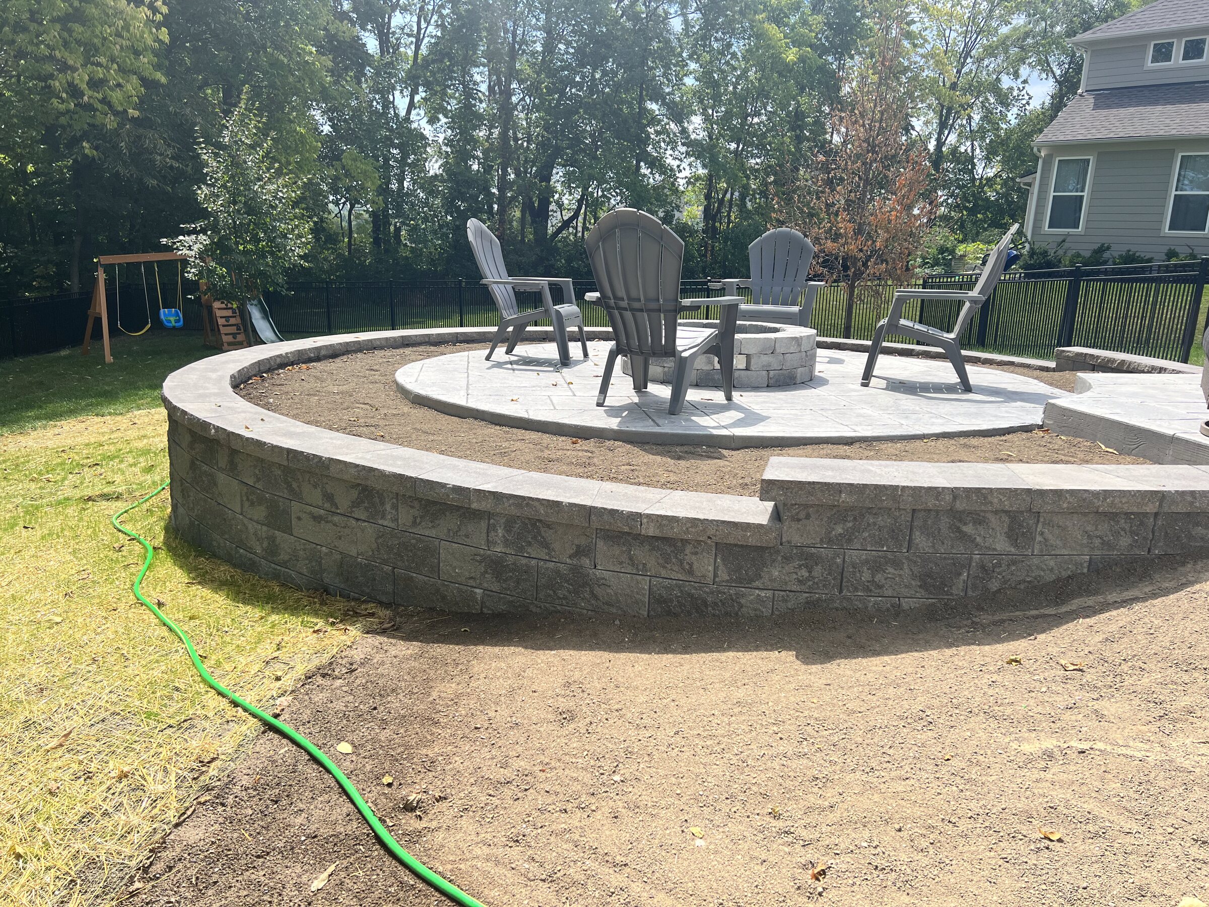 Sitting wall being laid on a new stamped patio before backfill