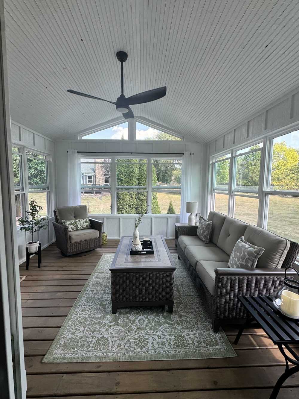 Finished sunroom with vaulted ceiling, fan and lounge seating